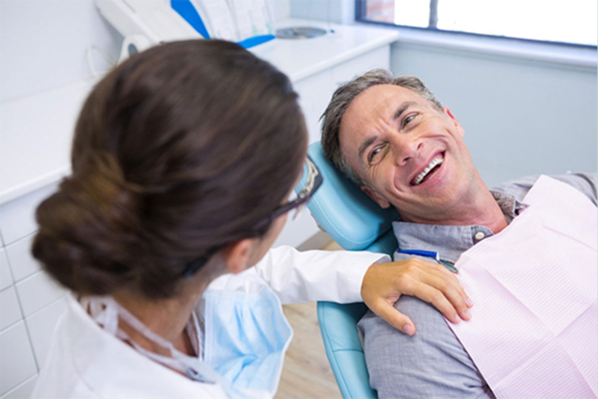 Dental patient speaking with a clinician during treatment, representing uninterrupted care during clinic integration
