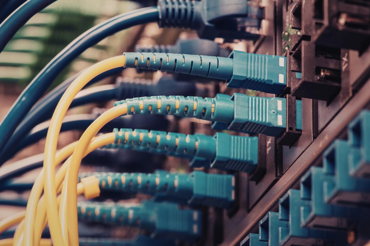 Close-up of cables connected to network equipment in a communications rack.