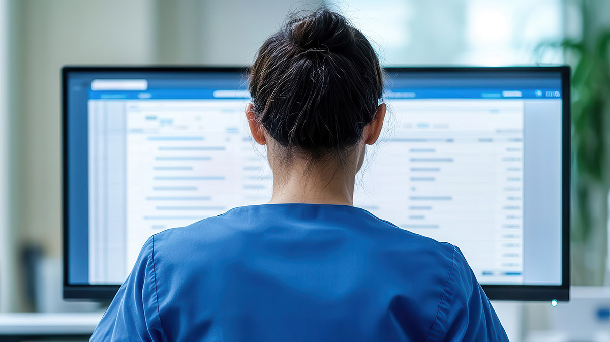medical employee looks at her computer screen